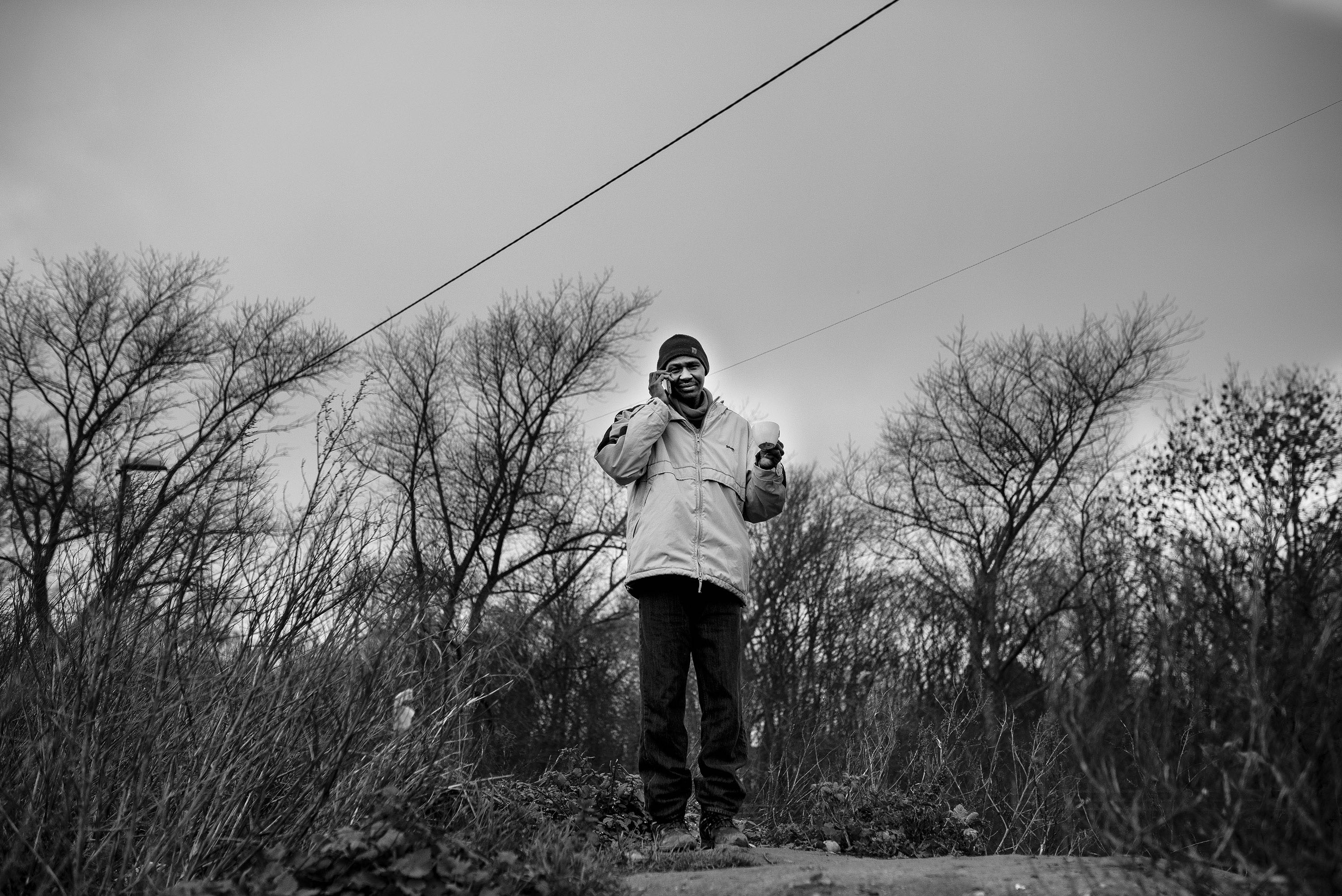 Mohamed takes a call while drinking his coffee.