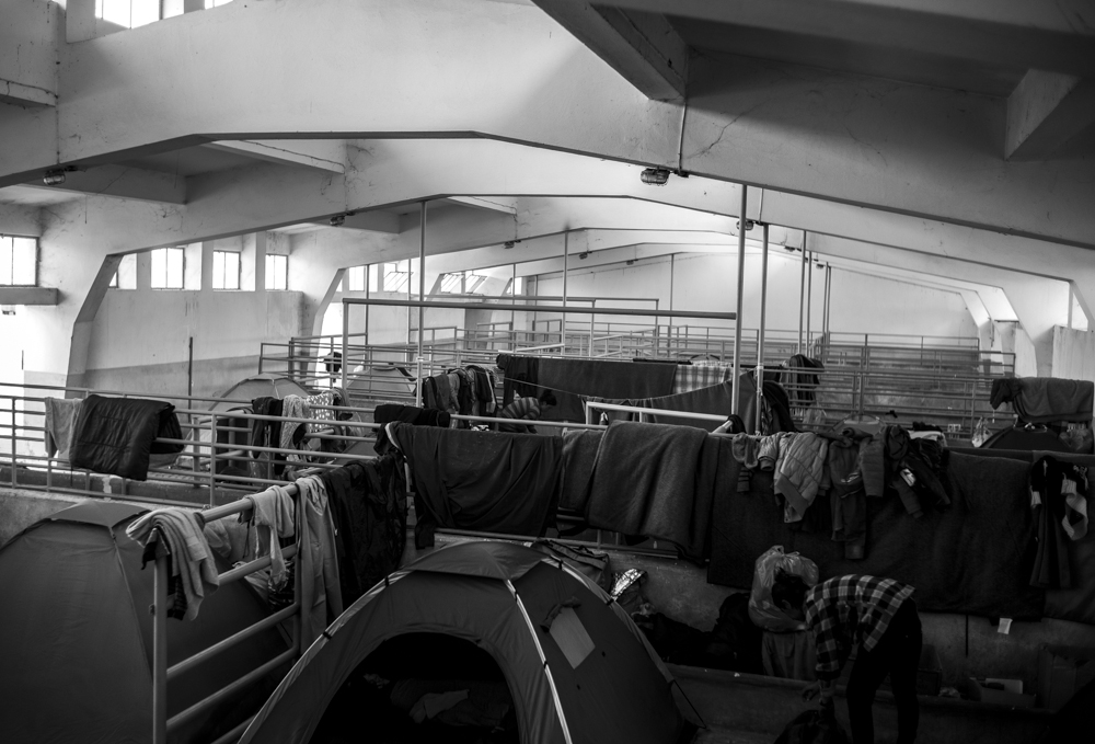 A depot converted into a camp space for migrants to set up tents.