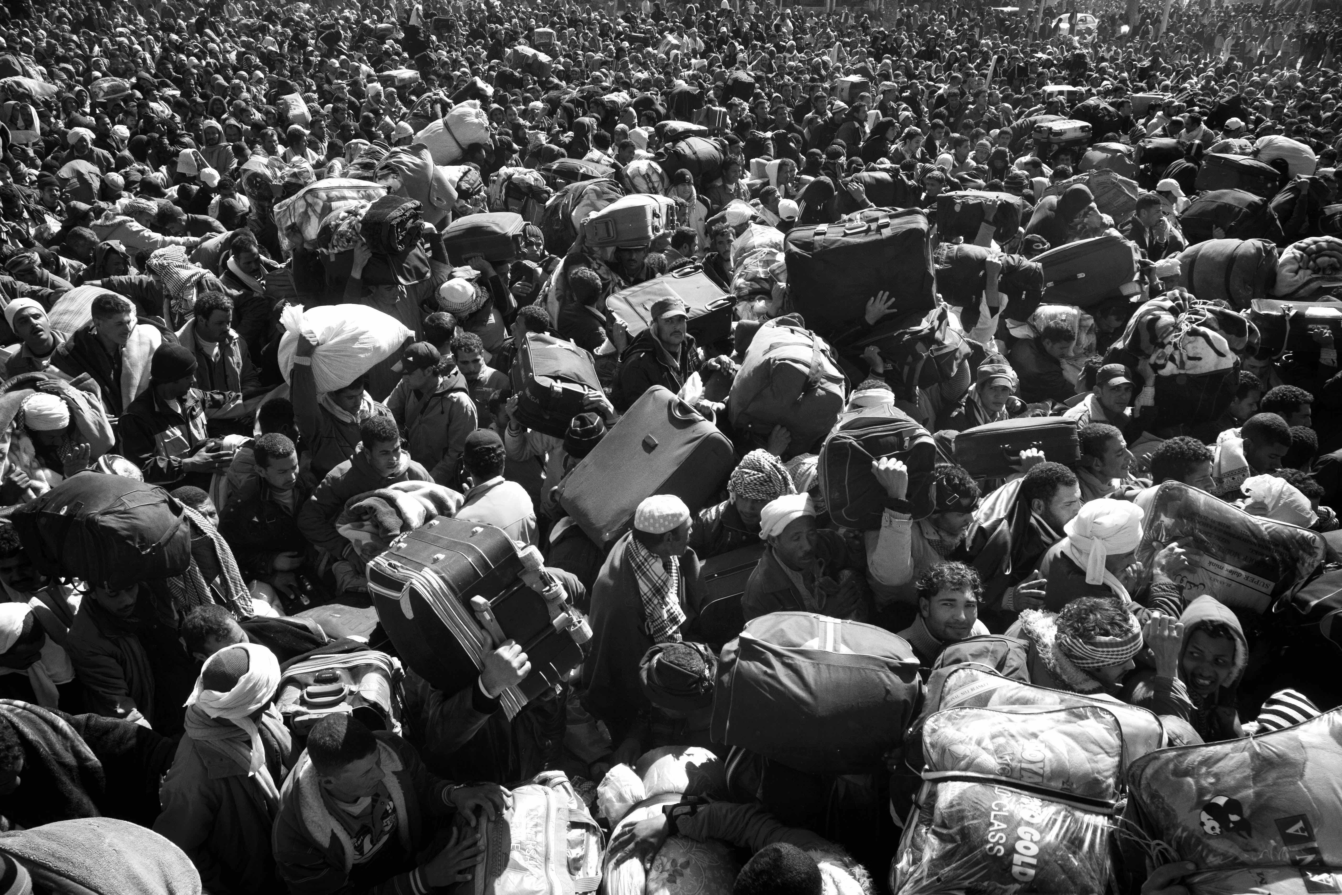 Tunisian, Egyptian and other nationals flee Libya during fighting between rebels and pro Qaddafi forces and arrive at the border crossing in Ras Jdir near Ben Gardenne, Tunisia. 2011 © Paolo Pellegrin/Magnum Photos