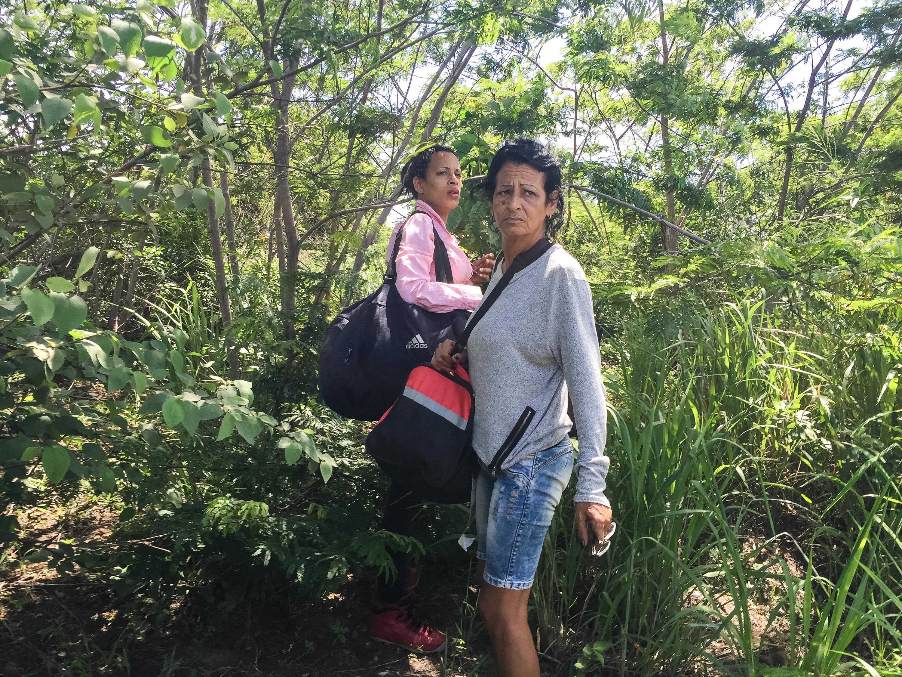 After crossing into Brazil, Marta and Liset wait nervously for the signal to run to awaiting cars.