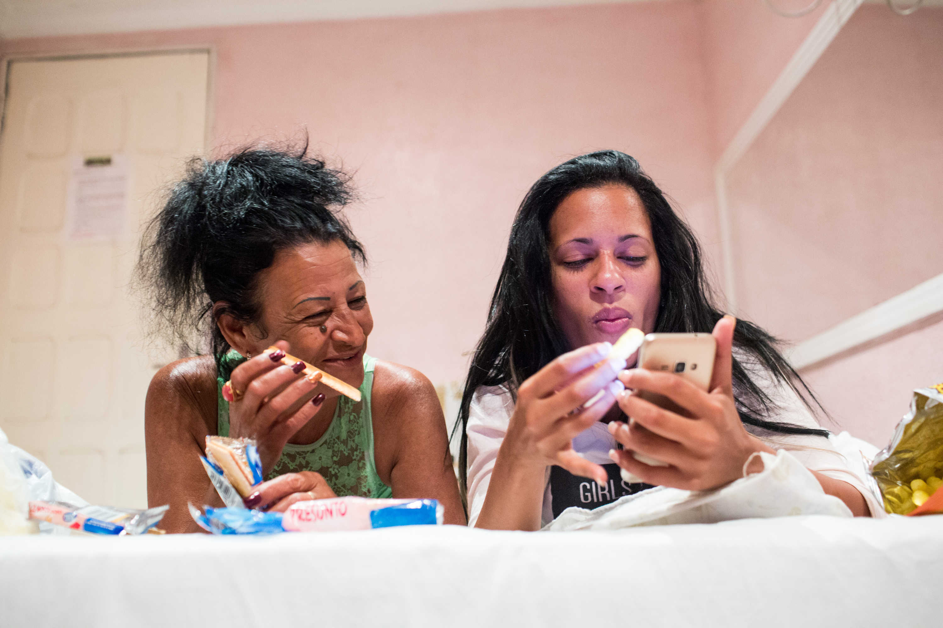 Liset and Marta talk with friends from a hotel room in Brazil.