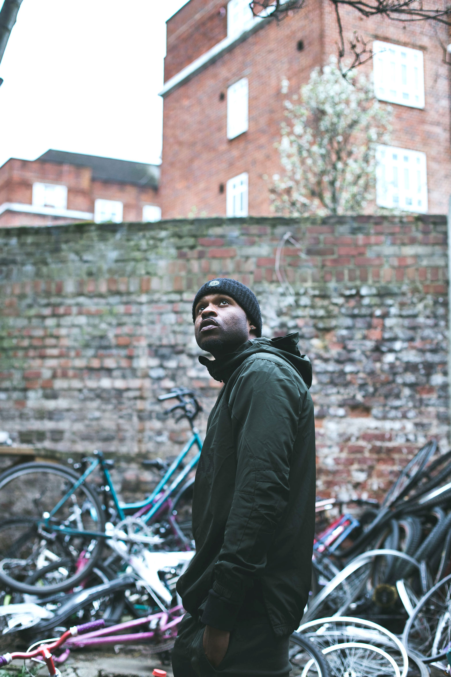Mac stands in front of a pile of bike carcasses at the Cycle Pitstop.