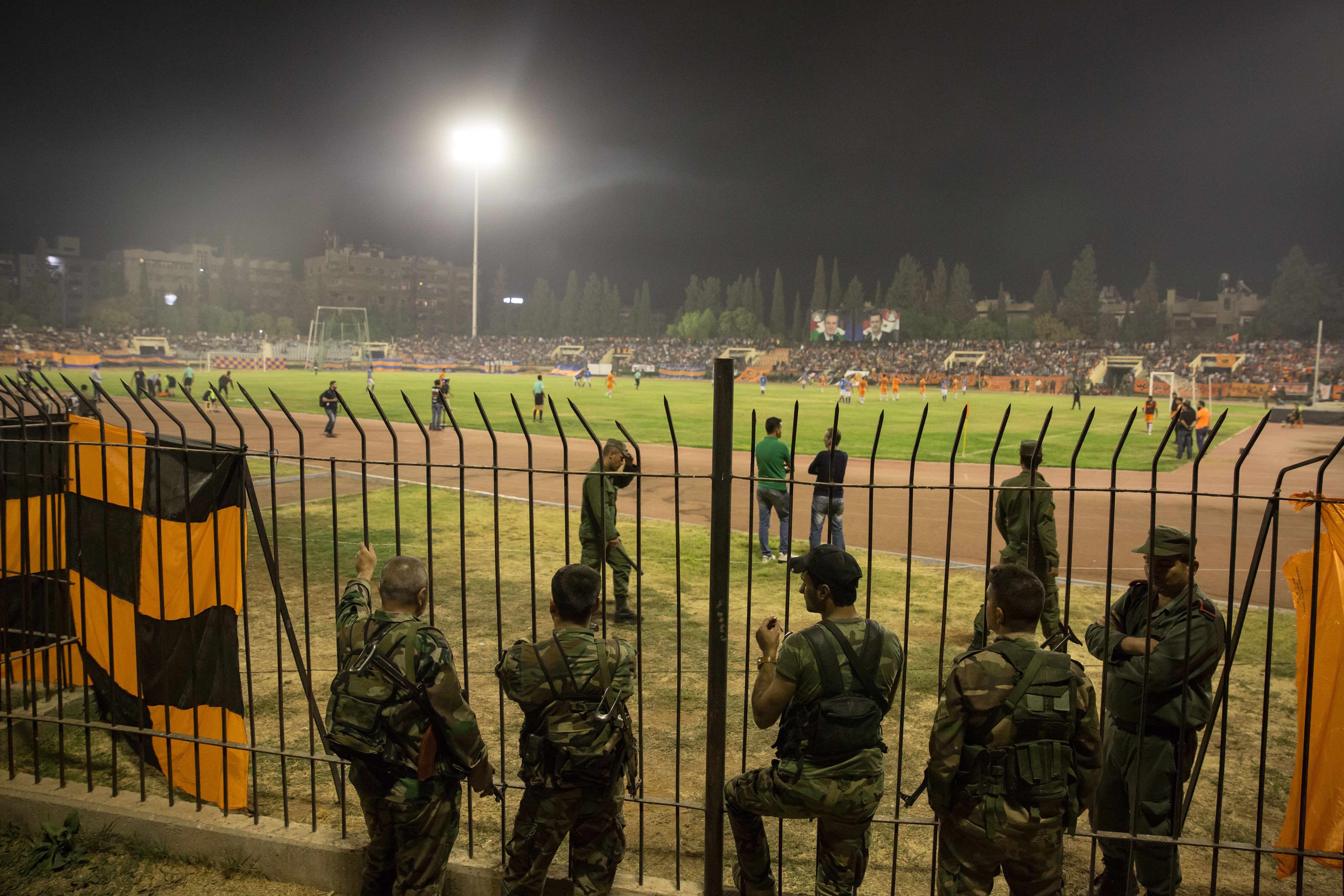 Soldiers line the pitch during the Syrian Cup final. Some also stood in the crowd, watching out for security breaches.