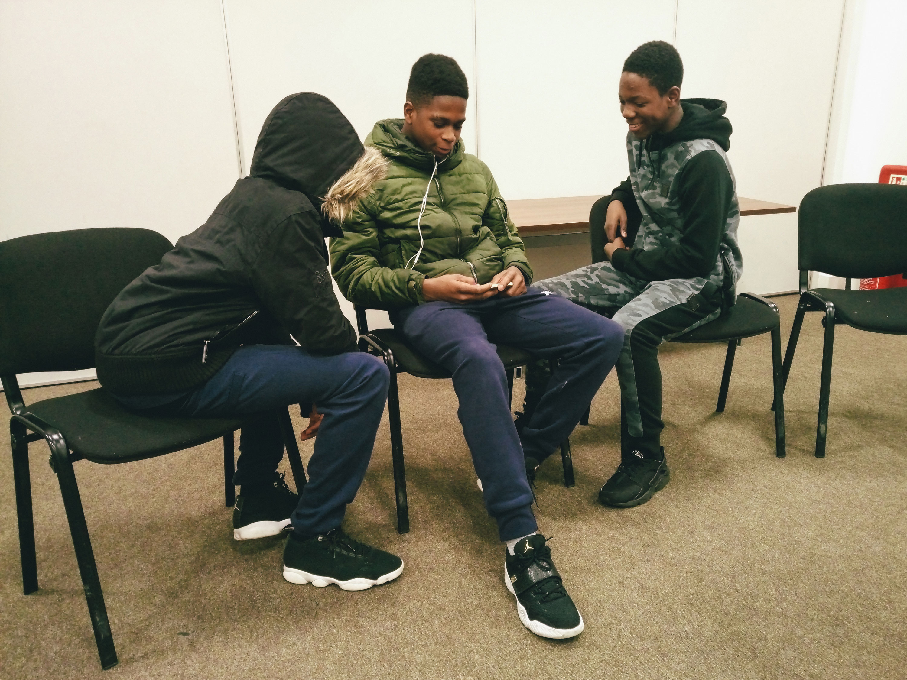 Boys playfully tease one another before the session begins and cell phones are collected to minimise distractions.
