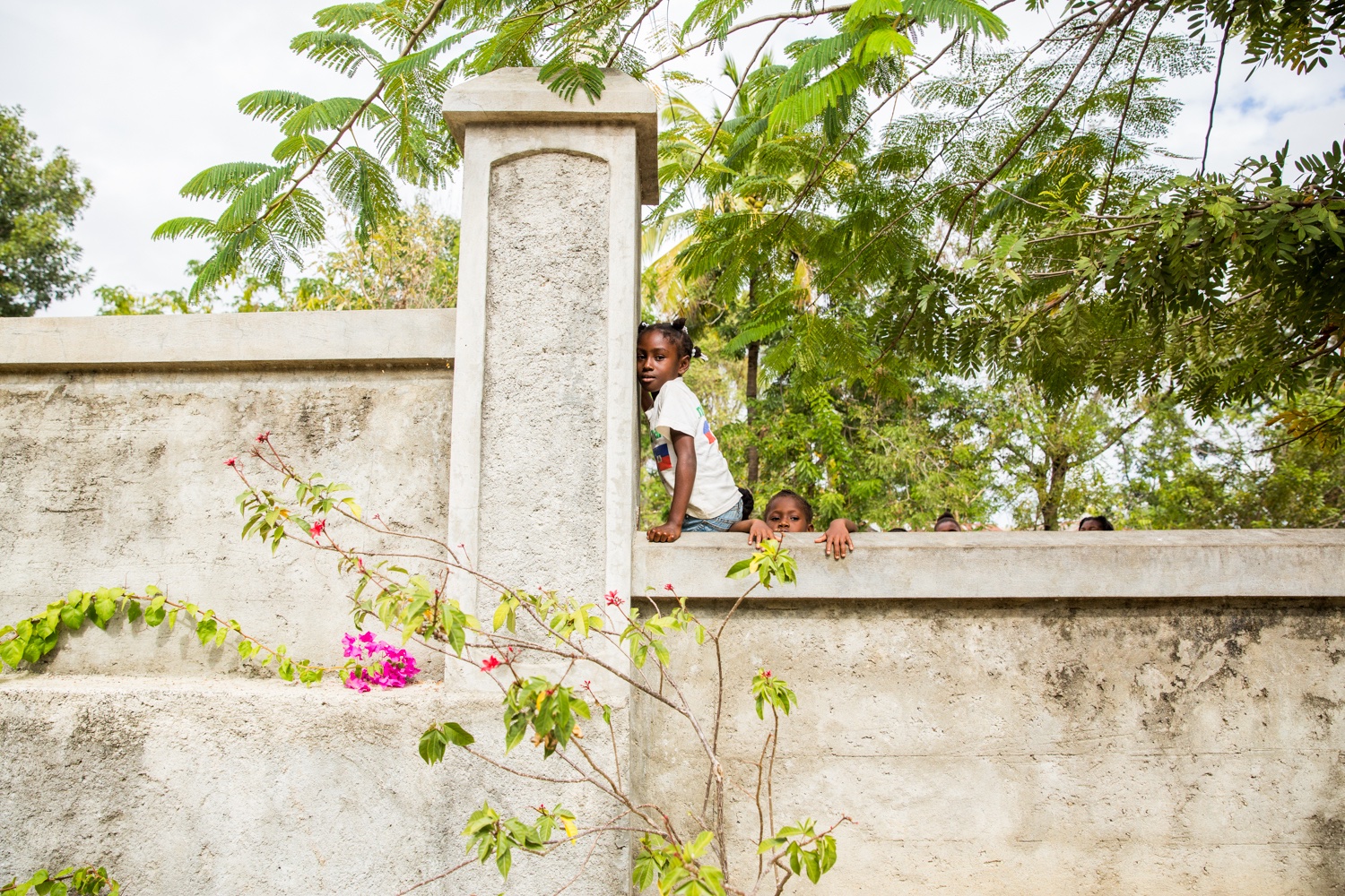Daughters of street vendors climbing a wall in Marmont, Central Plateau.