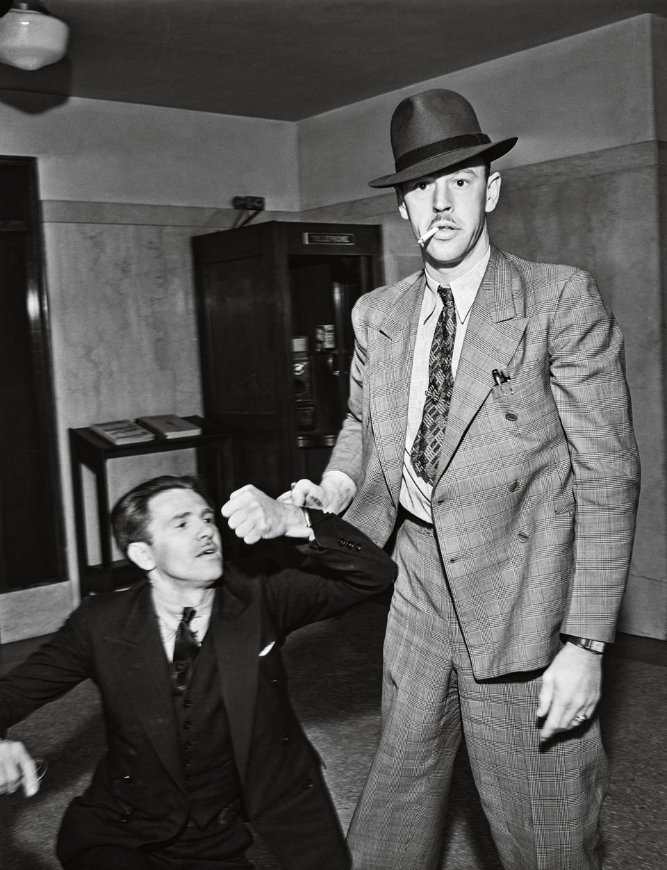 A reluctant suspect winces as a police officer takes things into his own hands, ca. 1934. Copyright: Cliff Wesselmann Photo Courtesy of Gregory Paul Williams, BL Press LLC / TASCHEN