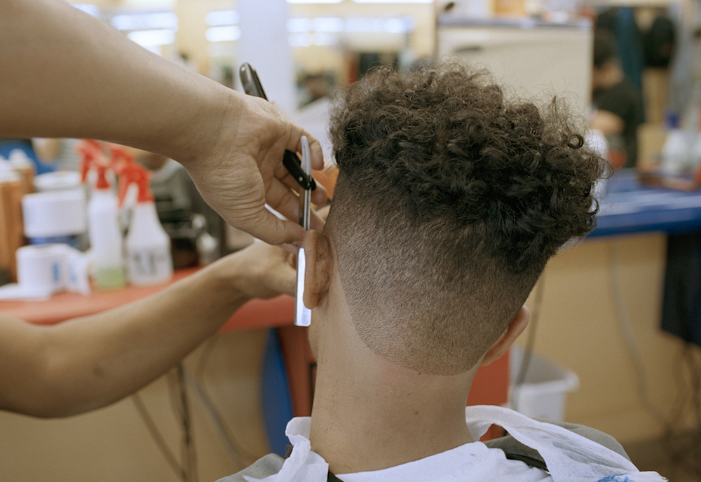 Ahmed Alzandhani gets a medium skin fade the day before a soccer match at a Dominican barbershop in the Flatbush neighborhood of Brooklyn, New York.