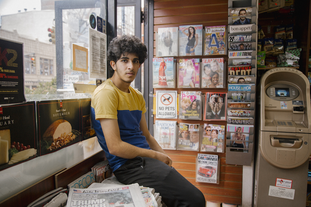Osama Alsahybi, 20, sits in his brother's deli in the Brooklyn Heights neighborhood of Brooklyn, New York. Osama has been in the U.S. for just under two years. Having zero English knowledge prior to coming to the US, he now speaks easily, laughs often and has made friends with all the regular customerrs who enter into the deli. To then, he's known simply as Oz.