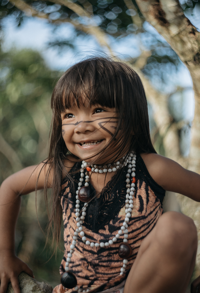 A young indigenous brazilian child wearing traditional clothing with facepaint